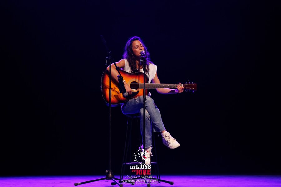 Une artiste chante en s'accompagnant à la guitare